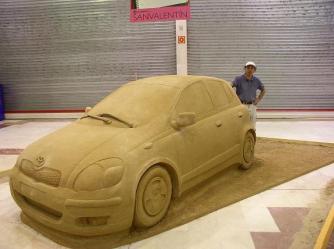 Life size sand sculpture of a car.