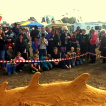 Crowds watching the sand becoming a dragon.